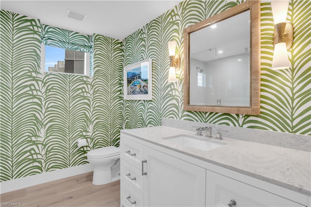 13945 Old Coast Road, Unit 301 Naples, FL 34110 - Photo 24 of 30 a bathroom with a sink a mirror and a toilet