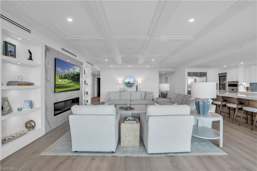 13945 Old Coast Road, Unit 301 Naples, FL 34110 - Photo 6 of 30 a living room with fireplace furniture and a flat screen tv