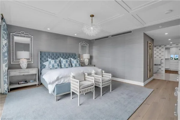 a bedroom with a bed and a chandelier