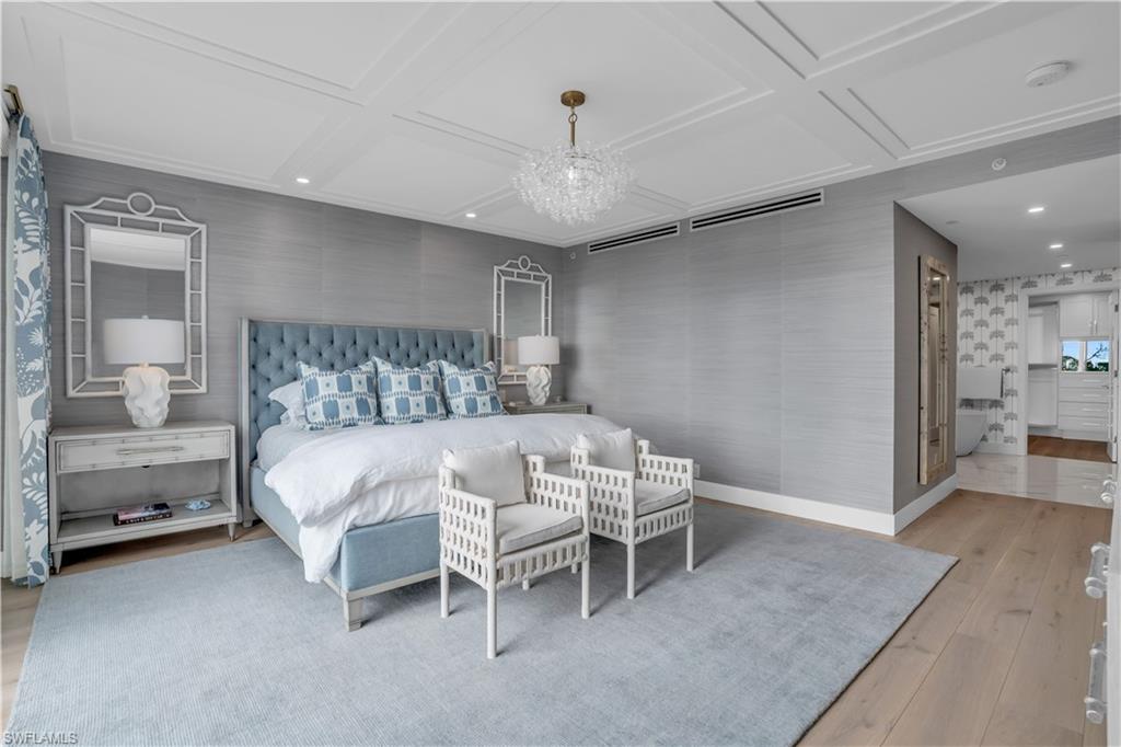 13945 Old Coast Road, Unit 301 Naples, FL 34110 - Photo 9 of 30 a bedroom with a bed and a chandelier