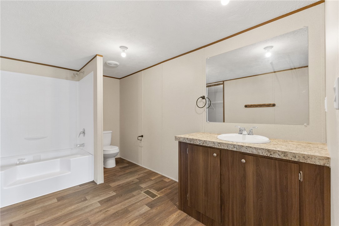 1014 Doe Run Road Caldwell, TX 77836 - Photo 15 of 23 a bathroom with a granite countertop sink a mirror and a bathtub