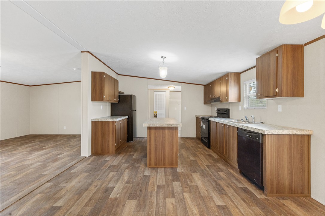 1014 Doe Run Road Caldwell, TX 77836 - Photo 10 of 23 a large kitchen with kitchen island a sink a stove a refrigerator and white cabinets with wooden floor