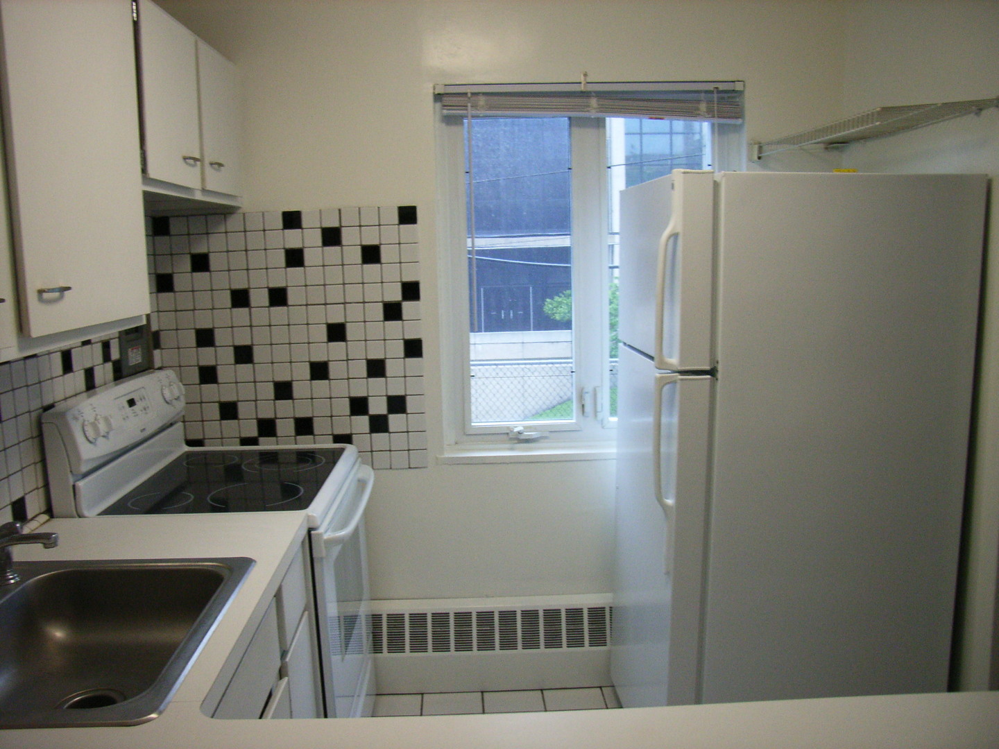 700 West Bittersweet Place, Unit 207 Chicago, IL 60613 - Photo 4 of 11 a kitchen with a sink a refrigerator and cabinets