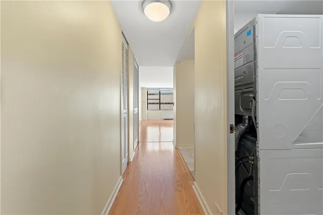a view of a hallway with wooden floor and closet