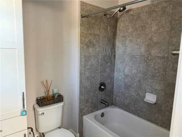 a bathroom with a sink a toilet a mirror and shower