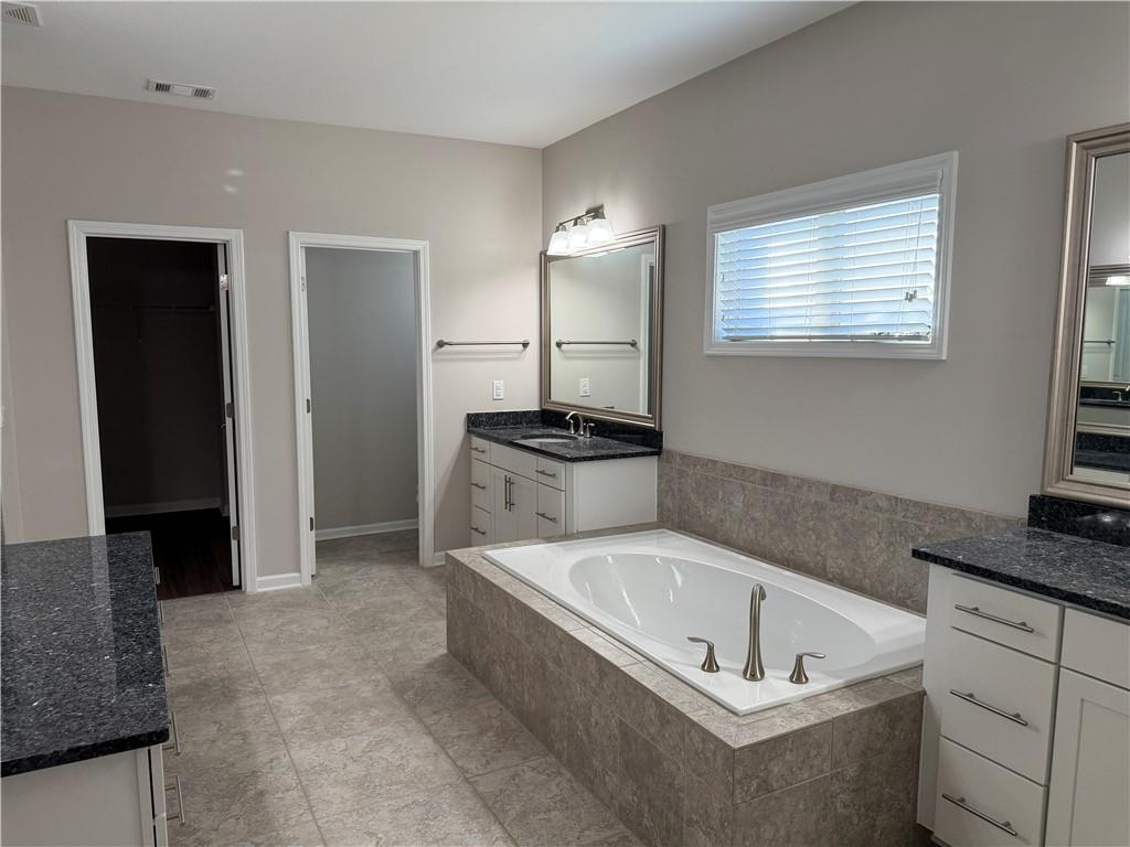 5670 Bridleton Crossing Suwanee, GA 30024 - Photo 15 of 23 a bathroom with a bathtub and a sink