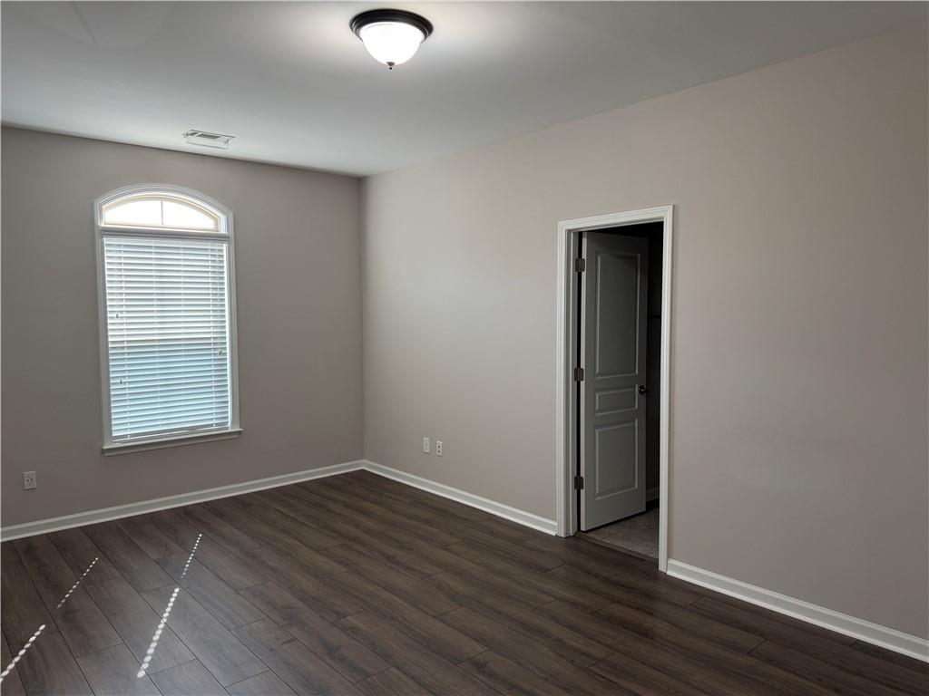 5670 Bridleton Crossing Suwanee, GA 30024 - Photo 18 of 23 an empty room with wooden floor and windows