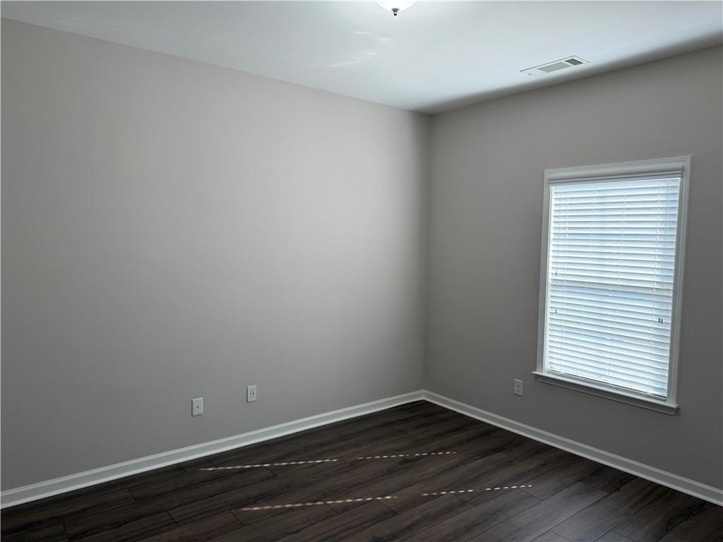 5670 Bridleton Crossing Suwanee, GA 30024 - Photo 20 of 23 a view of an empty room with wooden floor and a window