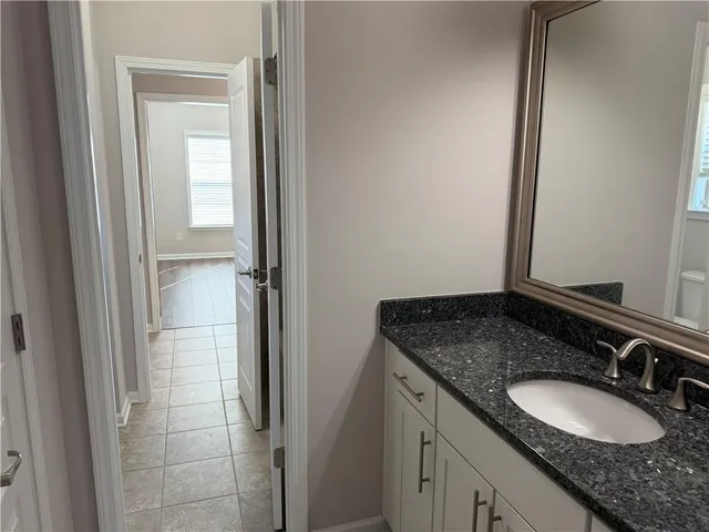 a bathroom with a granite countertop sink and a mirror