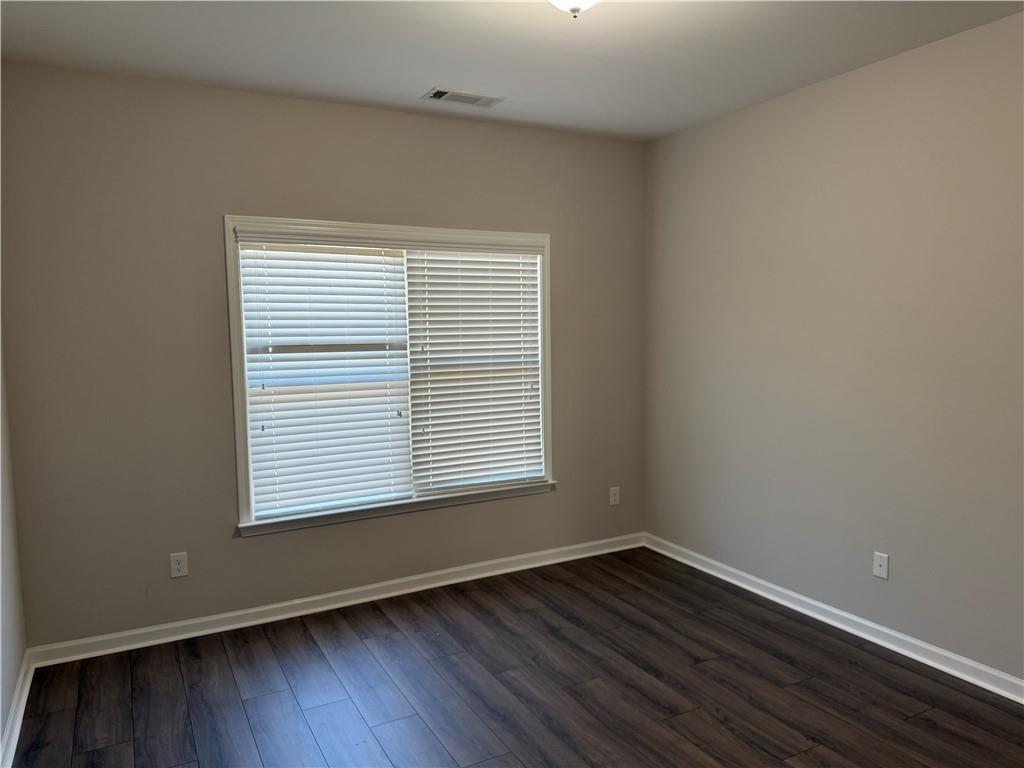 5670 Bridleton Crossing Suwanee, GA 30024 - Photo 22 of 23 a view of an empty room with wooden floor and a window