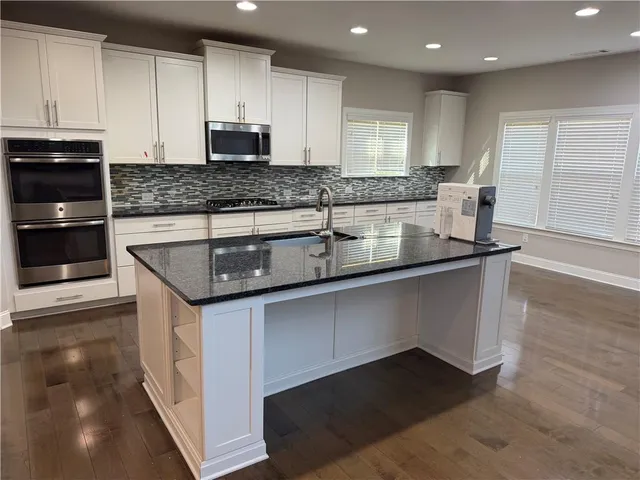 a kitchen with granite countertop a sink and a stove