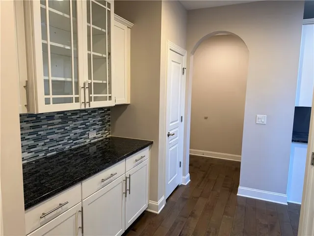 a kitchen with granite countertop a sink and a stove next to a window