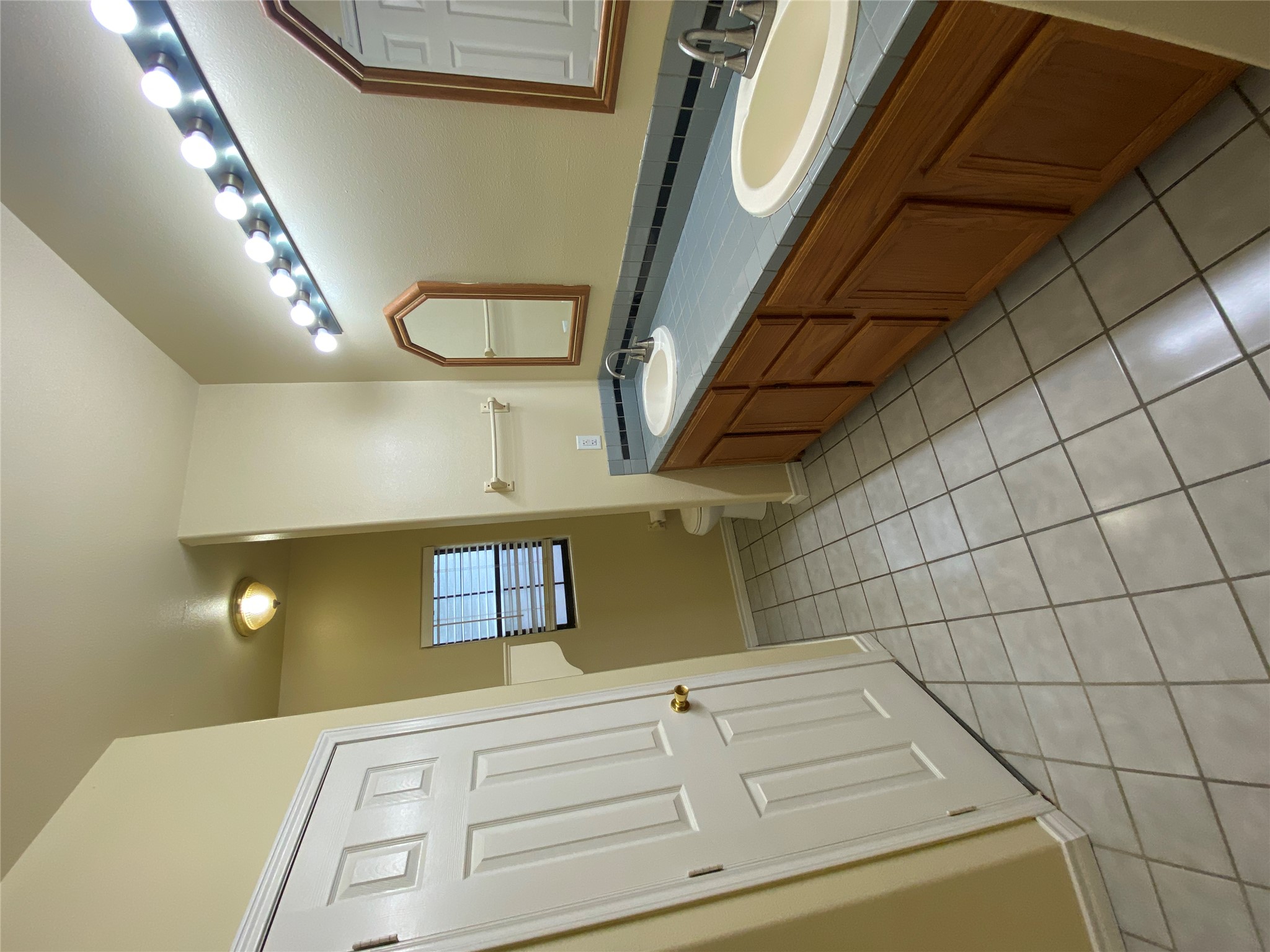 2605 Alcott Lane, Unit B Austin, TX 78748 - Photo 13 of 15 A well-lit primary bathroom features a double vanity and durable tile flooring, creating a functional space.