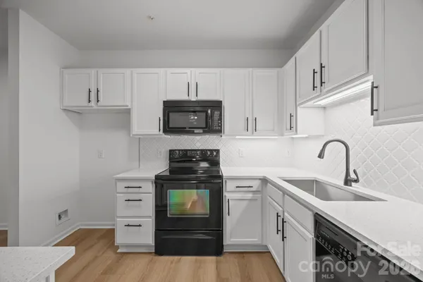 a kitchen with cabinets stainless steel appliances and a sink