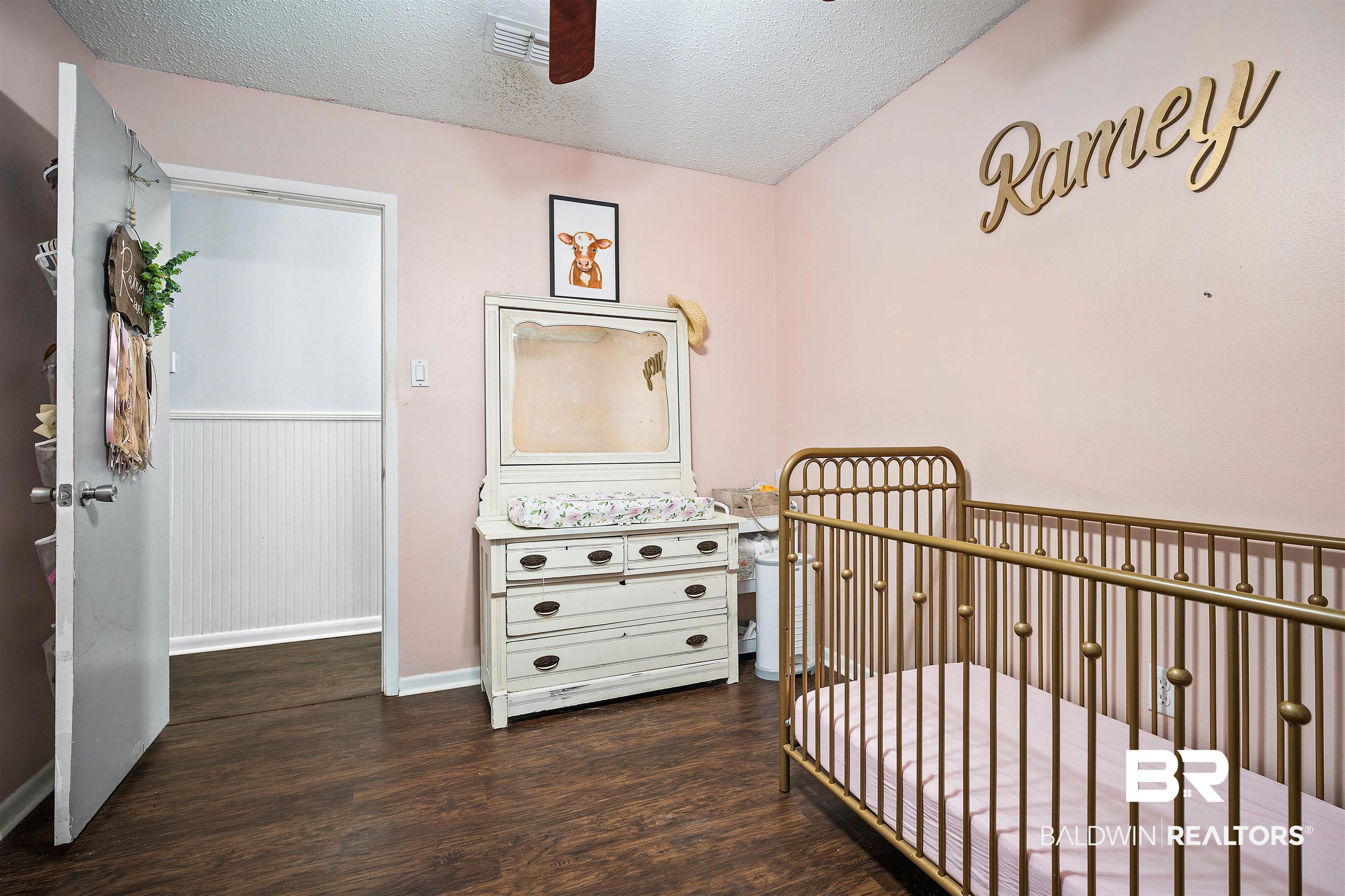 5110 Wilmer Road Wilmer, AL 36587 - Photo 19 of 24 Bedroom with ceiling fan, dark hardwood / wood-style flooring, a crib, and a textured ceiling