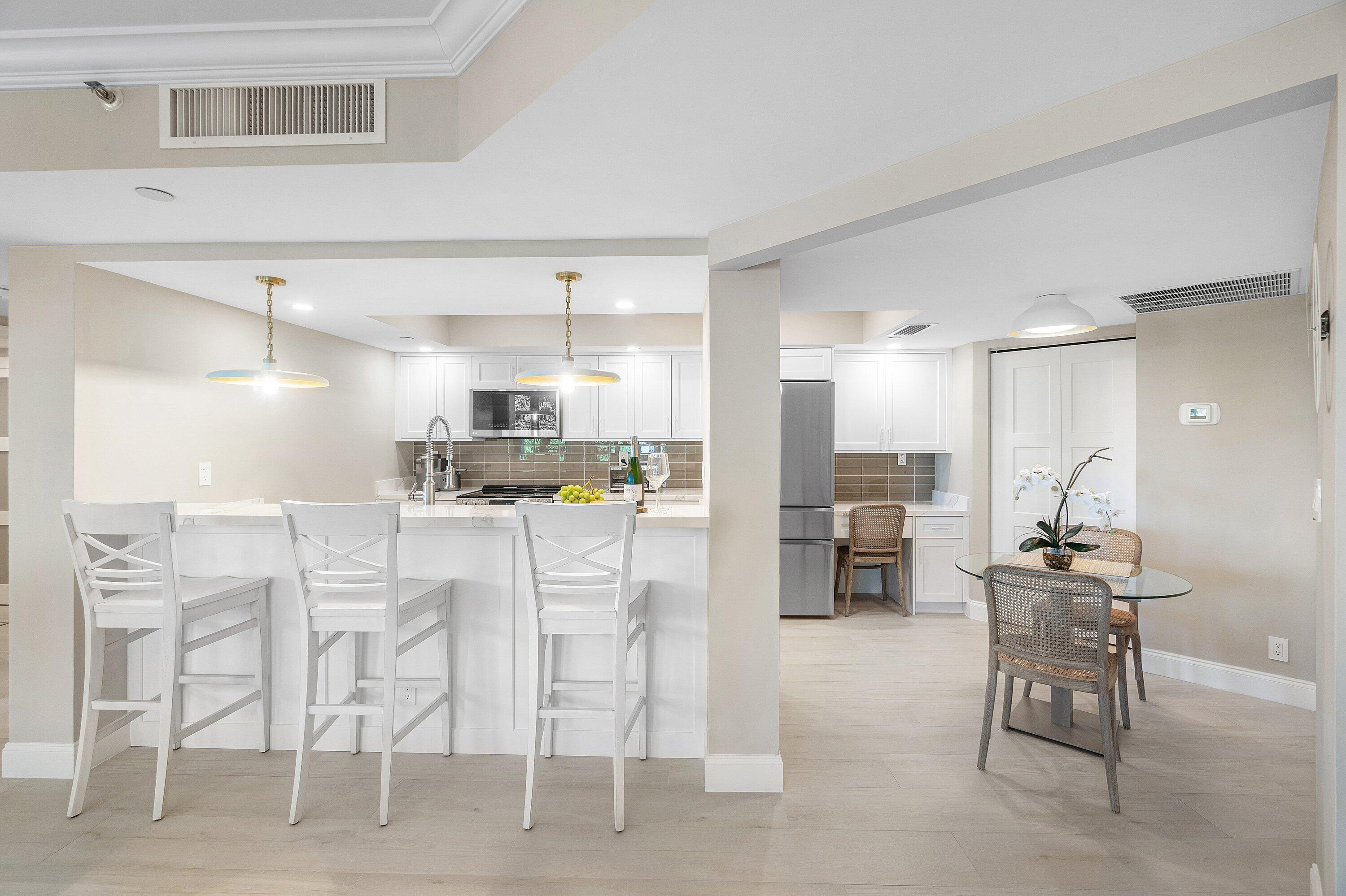 100 Southeast 5th Avenue, Unit 404 Boca Raton, FL 33432 - Photo 10 of 46 a kitchen with stainless steel appliances kitchen island granite countertop a refrigerator and cabinets