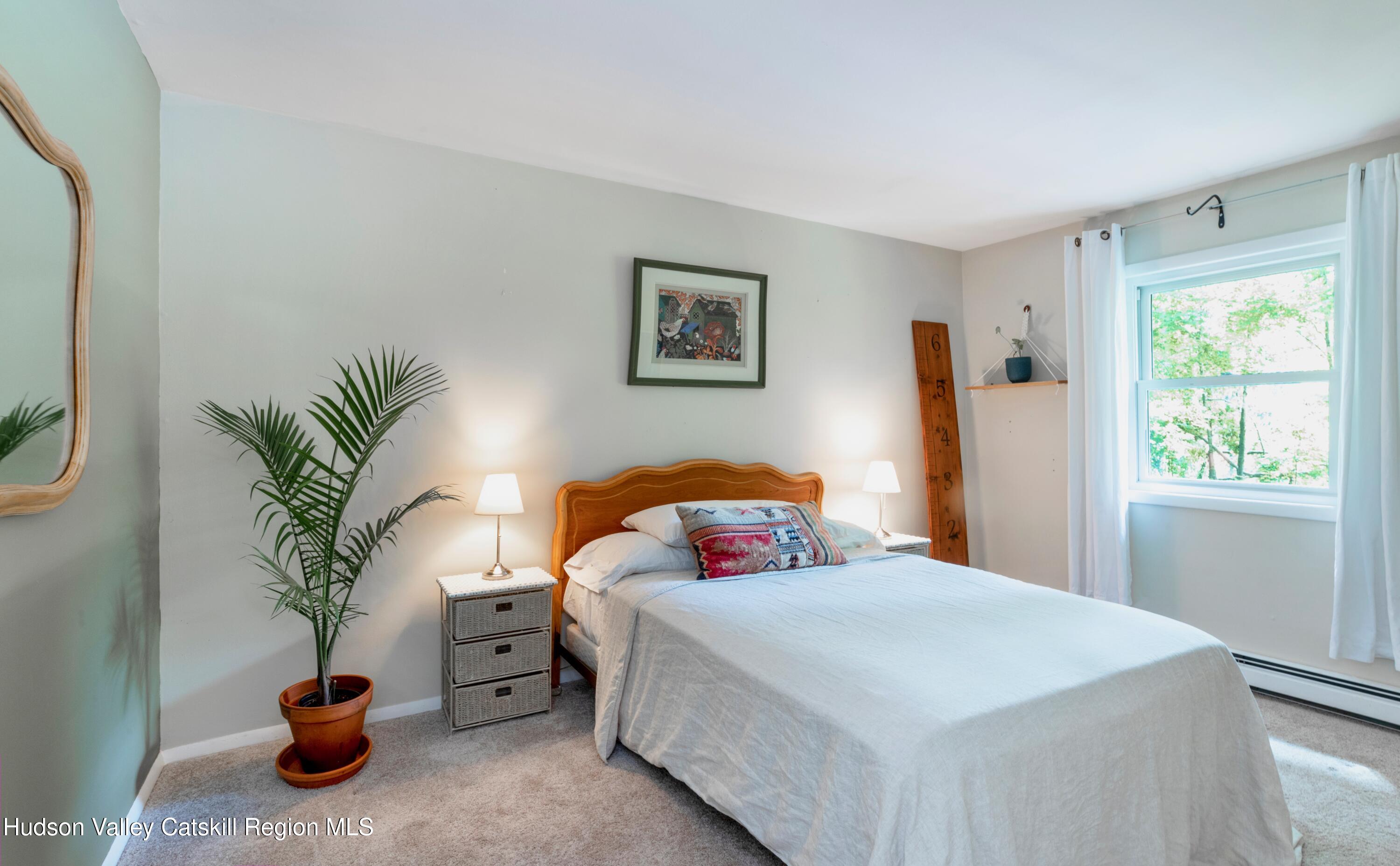 424 Tongore Way Kingston, NY 12401 - Photo 14 of 40 a bedroom with a bed and a potted plant