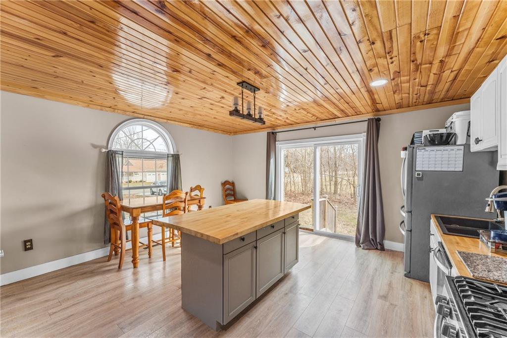 4400 Nye Road West Springfield, PA 16443 - Photo 11 of 31 a dining hall with stainless steel appliances granite countertop a stove and cabinets with wooden floor
