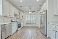 a view of a kitchen with a white cabinet and a stove top oven