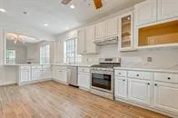 a kitchen with white cabinets and appliances