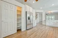 a view of empty room with wooden floor and entryway