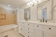 a bathroom with double vanity sink a bathtub and shower