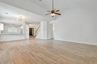 a view of an empty room with a chandelier fan