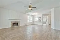 a view of an empty room with chandelier and fireplace