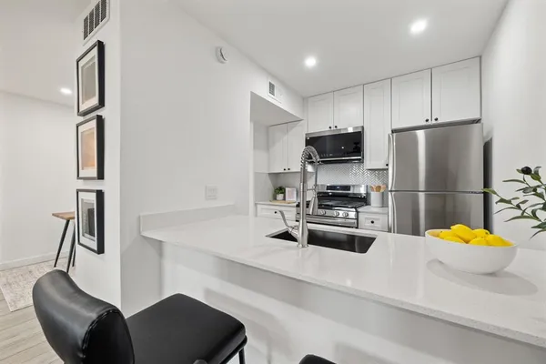 a kitchen with a sink cabinets and wooden floor