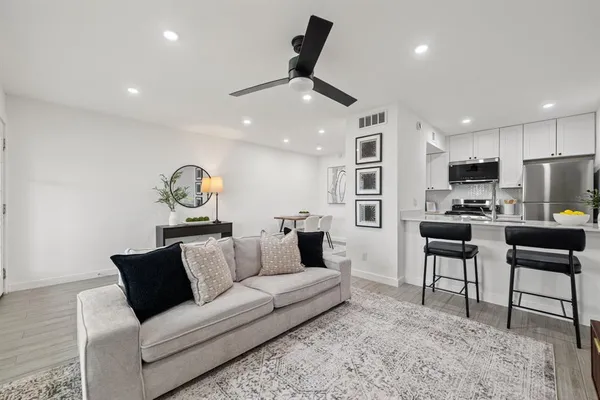 a living room with furniture and kitchen view