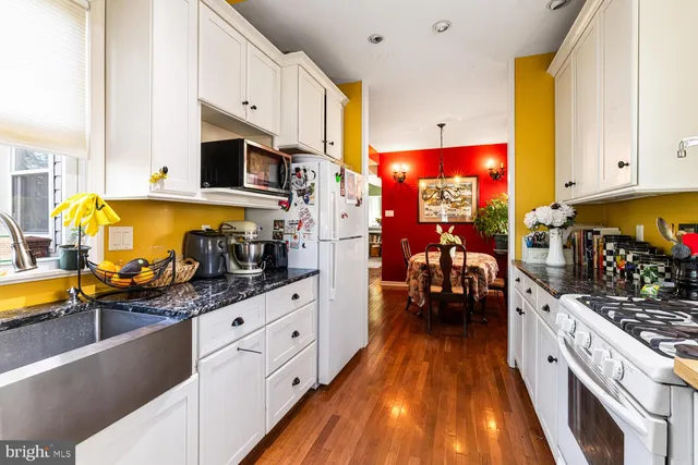 a kitchen with stainless steel appliances kitchen island granite countertop a stove and a sink