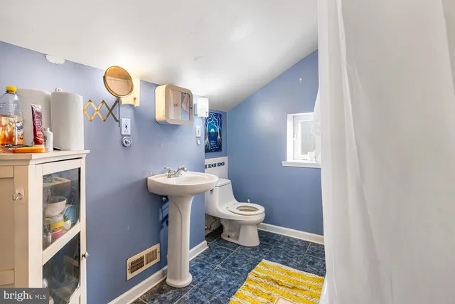 a bathroom with a sink a toilet and mirror