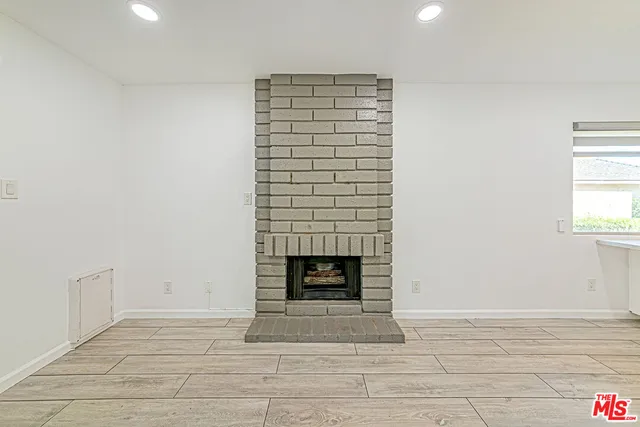 a view of an empty room with a fireplace and a window