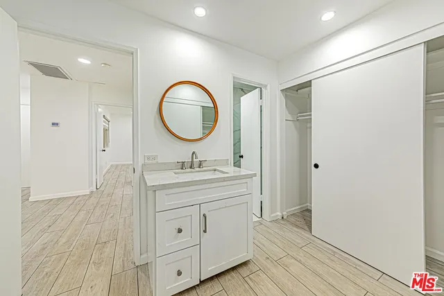 a white toilet sitting next to a bathroom sink and vanity