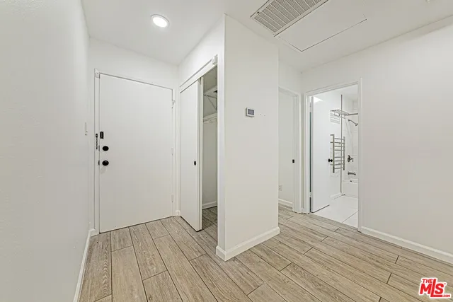 a view of empty room with wooden floor