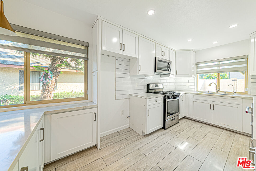 1941 Pine Drive La Habra, CA 90631 - Photo 7 of 35 a kitchen with white cabinets a sink a window and stainless steel appliances