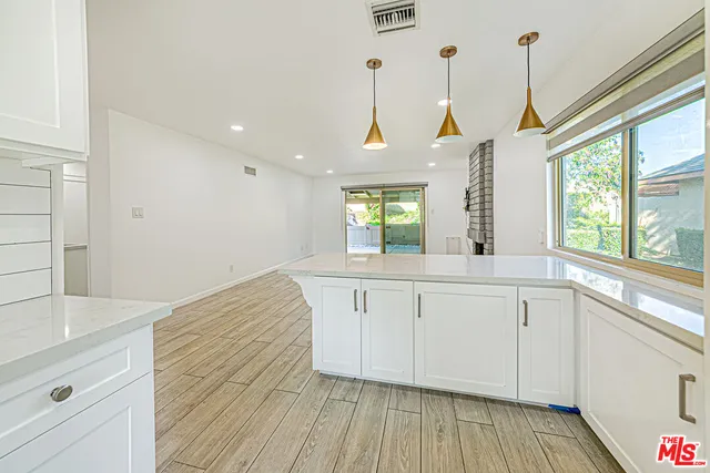 a view of a kitchen with wooden floor and windows
