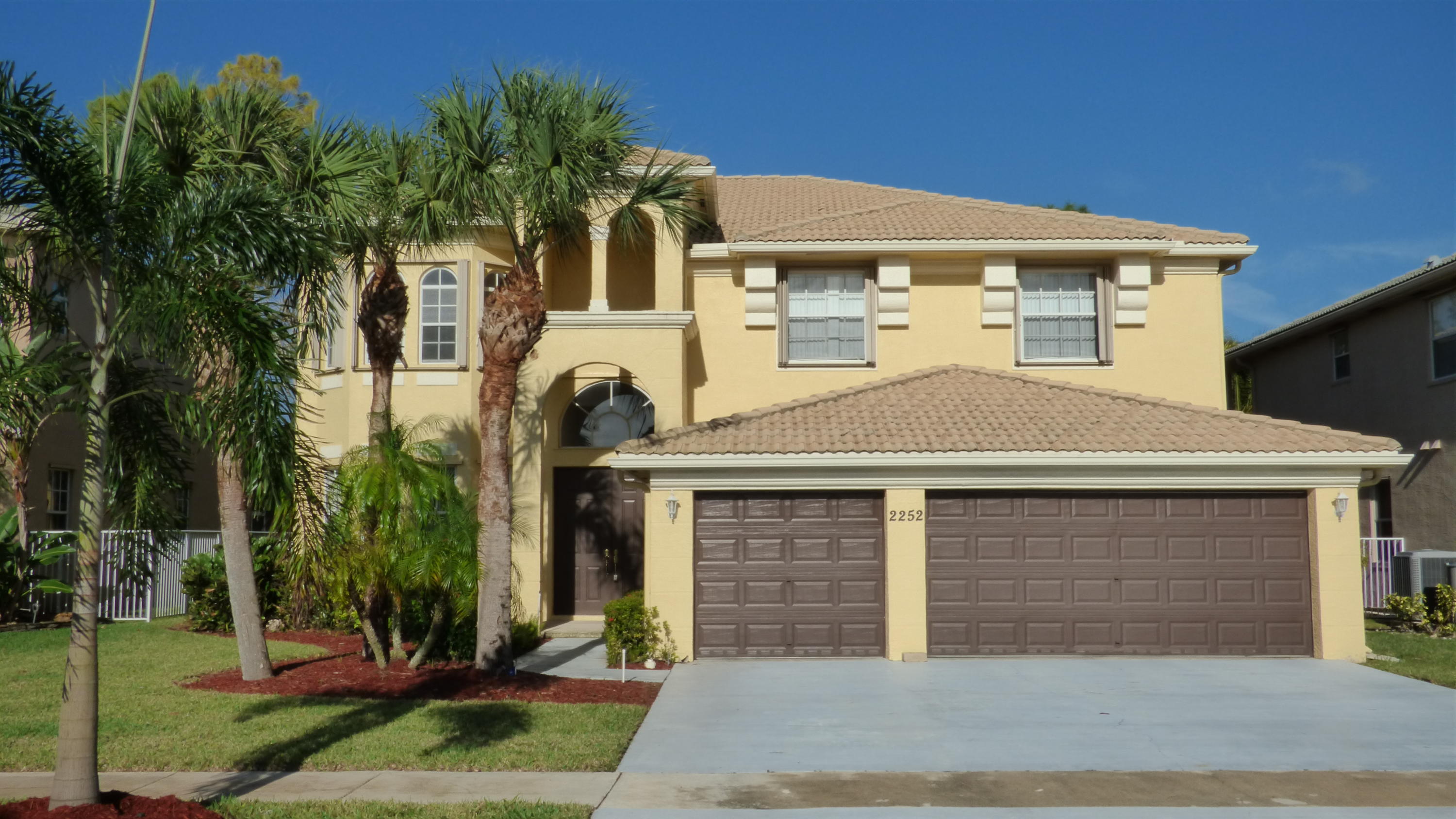 2252 Ridgewood Circle Royal Palm Beach, FL 33411 - Photo 1 of 40 a front view of a house with garden