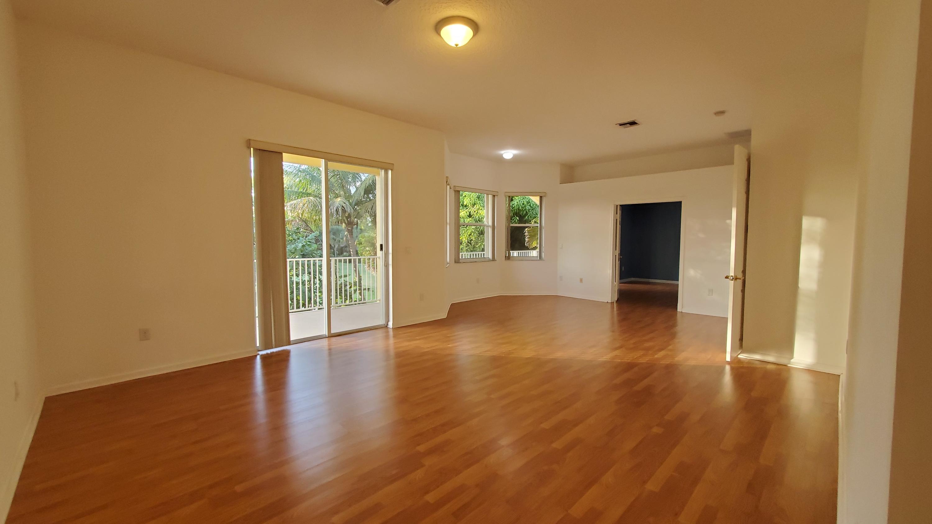 2252 Ridgewood Circle Royal Palm Beach, FL 33411 - Photo 15 of 40 a view of an empty room with wooden floor and a window