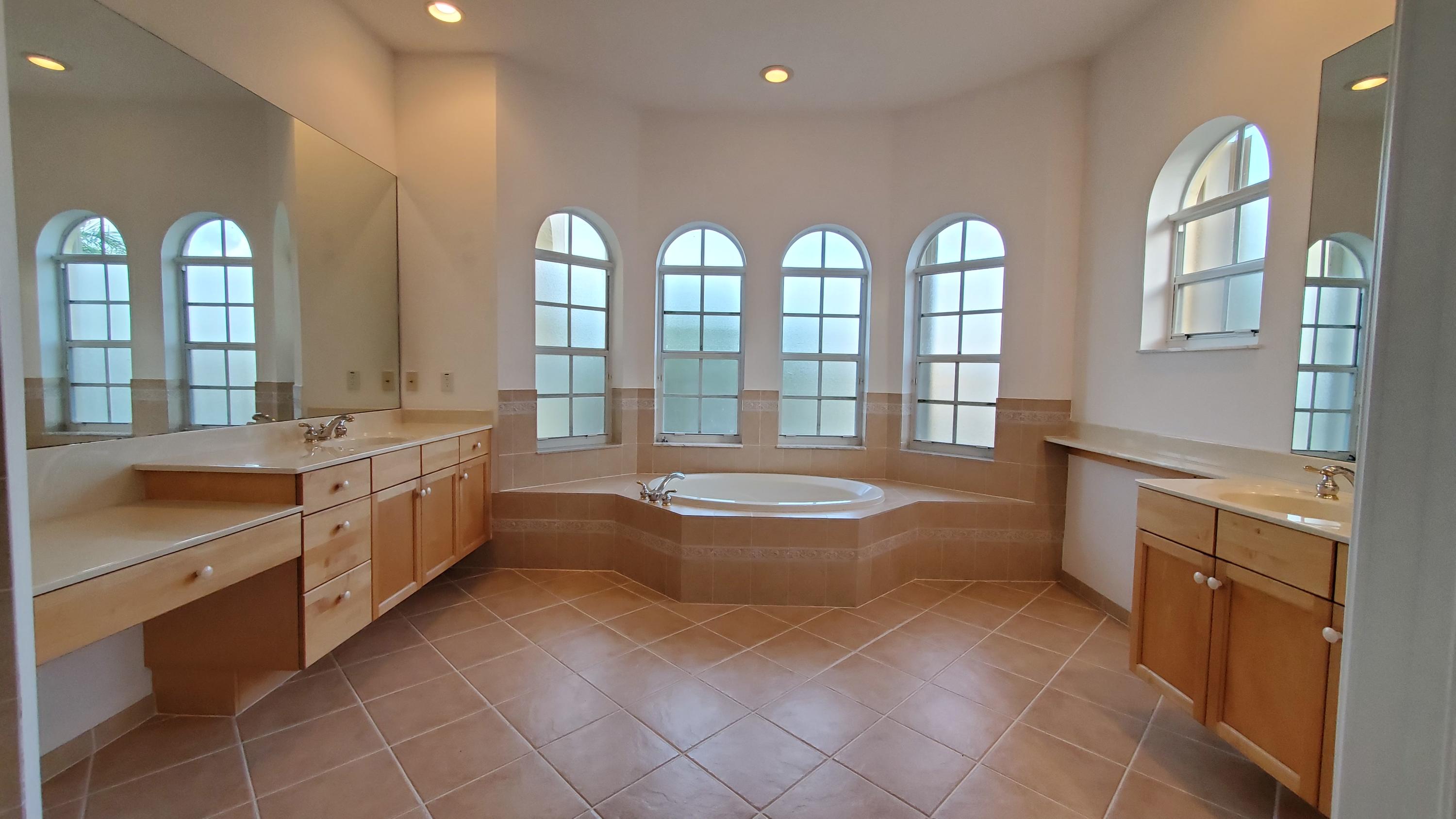 2252 Ridgewood Circle Royal Palm Beach, FL 33411 - Photo 17 of 40 a spacious bathroom with a double vanity sink a mirror and a bathtub