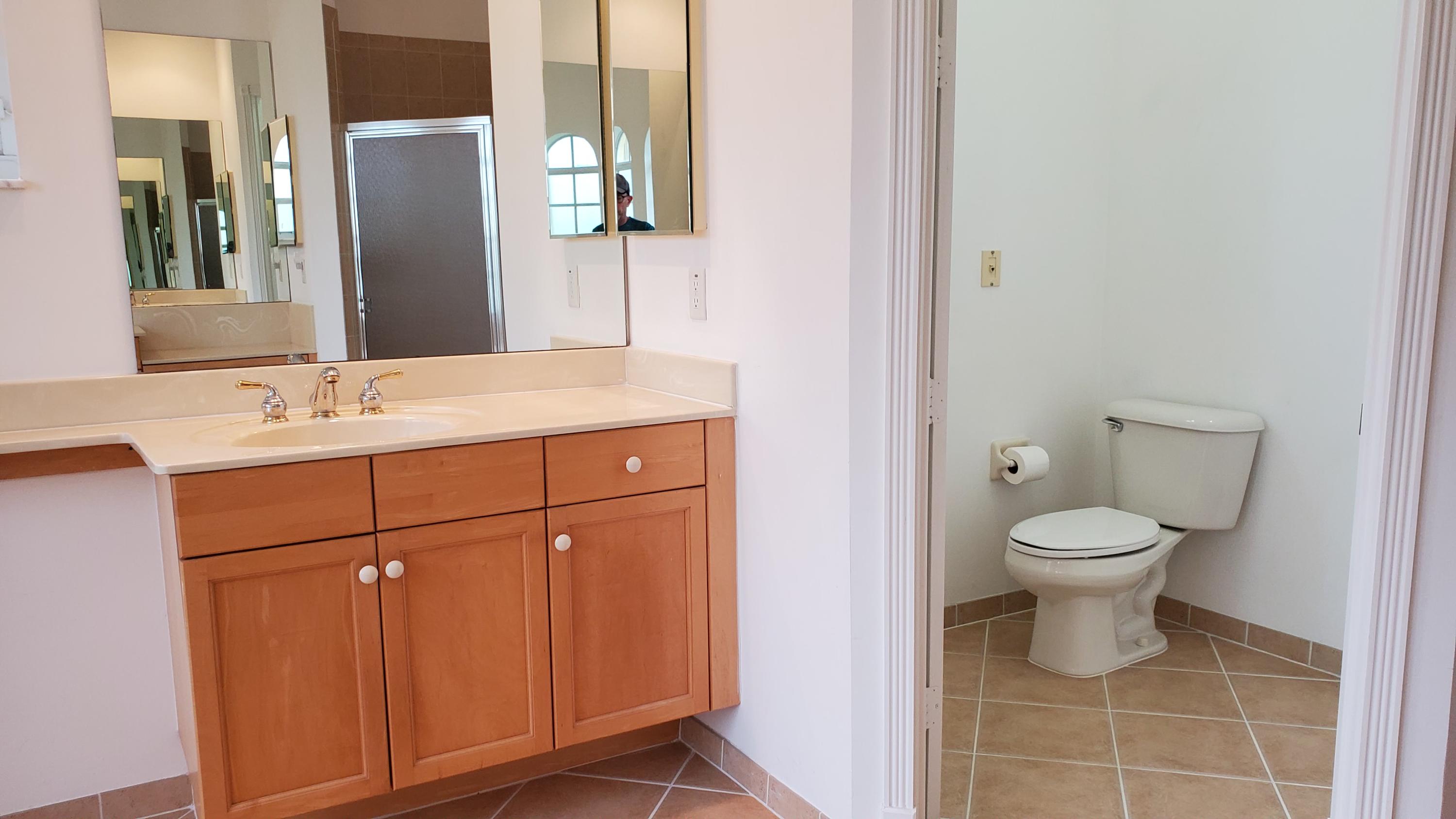 2252 Ridgewood Circle Royal Palm Beach, FL 33411 - Photo 19 of 40 a bathroom with a toilet sink and mirror