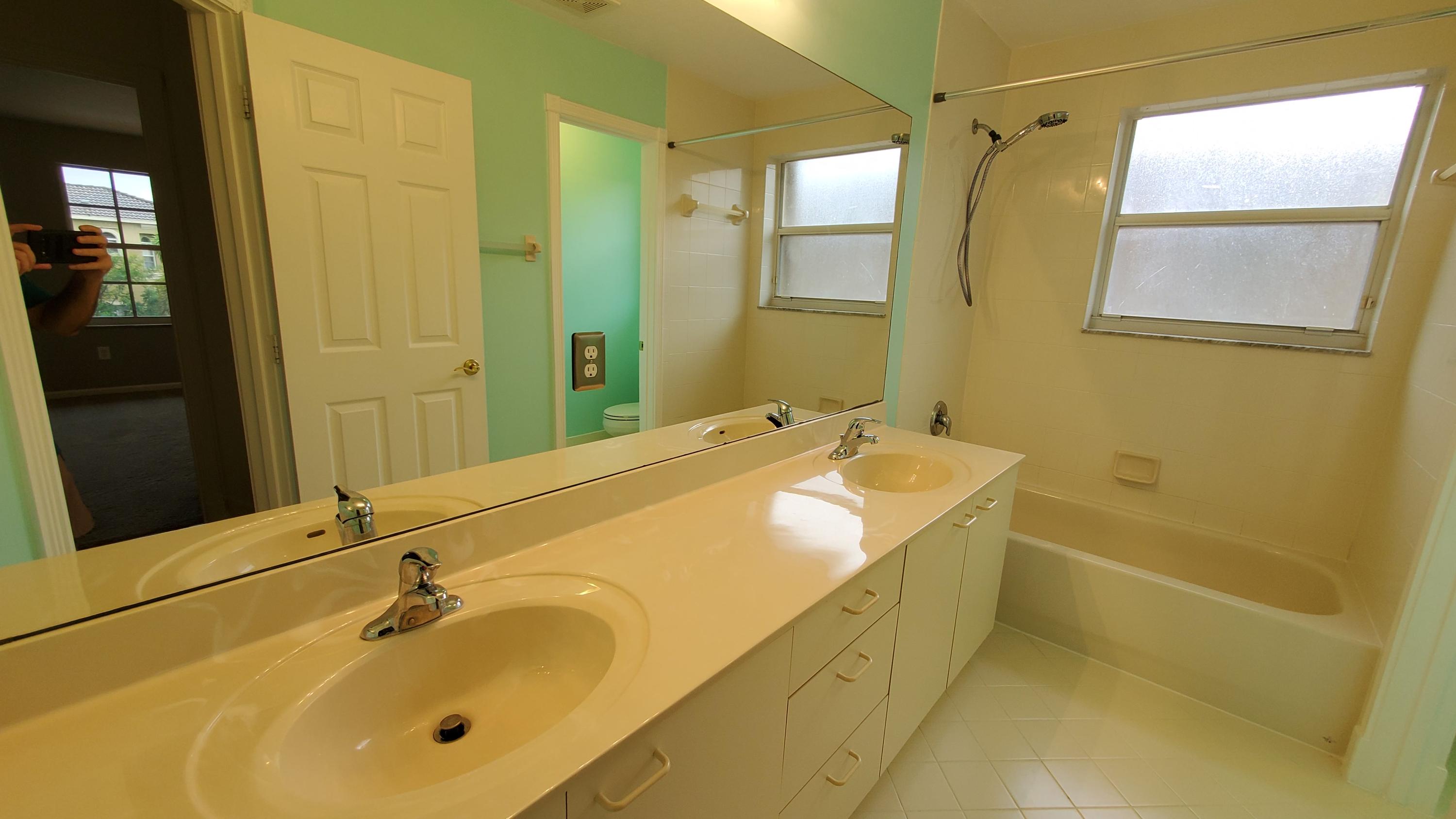 2252 Ridgewood Circle Royal Palm Beach, FL 33411 - Photo 28 of 40 a bathroom with a tub sink and mirror