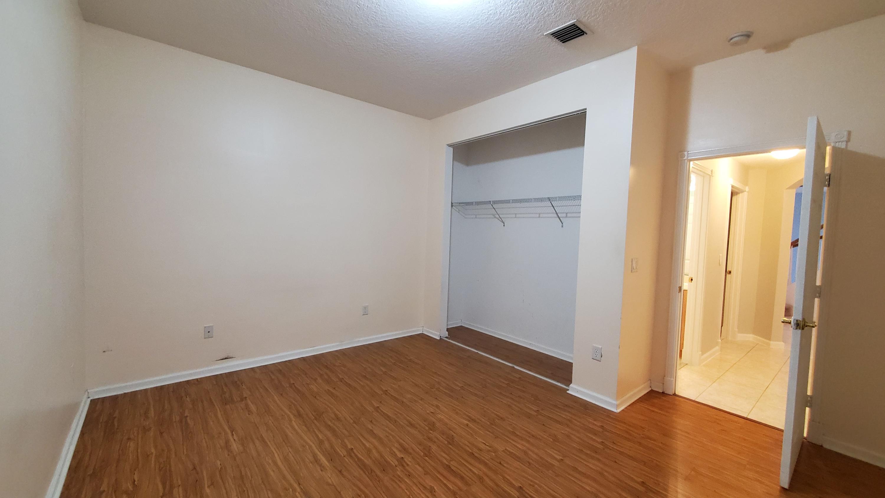 2252 Ridgewood Circle Royal Palm Beach, FL 33411 - Photo 30 of 40 a view of an empty room with wooden floor and a bathroom