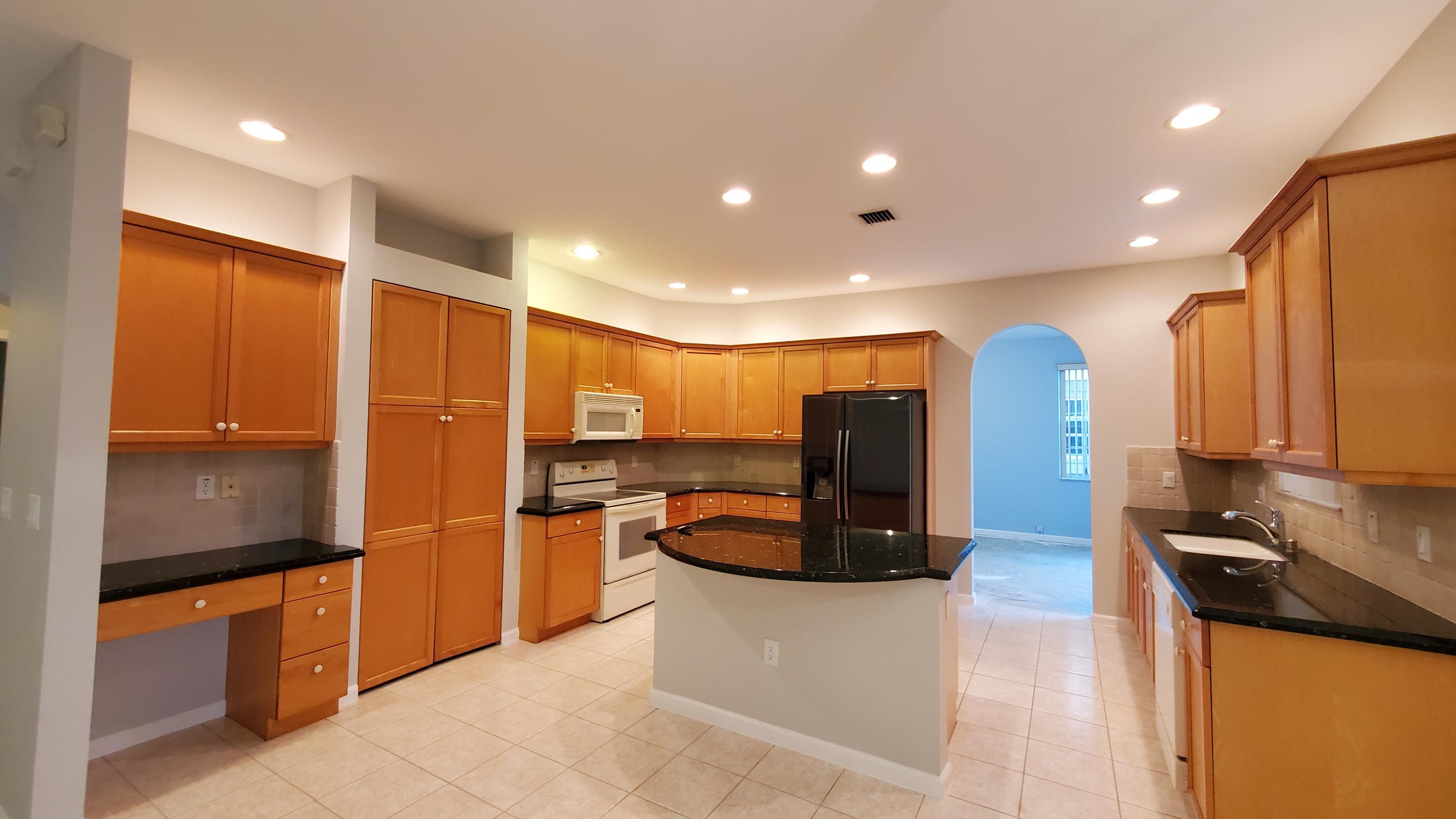 2252 Ridgewood Circle Royal Palm Beach, FL 33411 - Photo 3 of 40 a kitchen with stainless steel appliances granite countertop a refrigerator and a stove