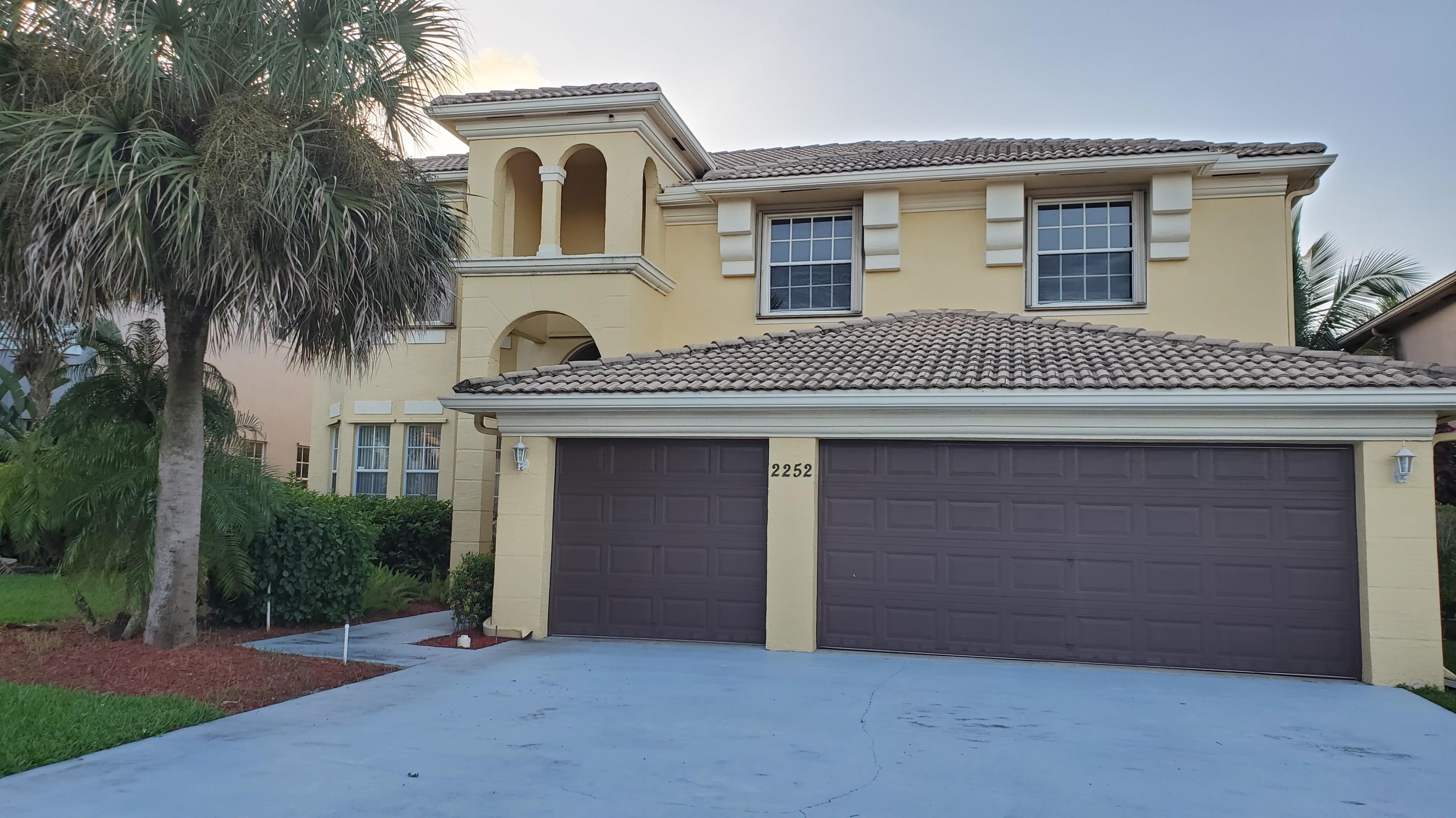 2252 Ridgewood Circle Royal Palm Beach, FL 33411 - Photo 40 of 40 a front view of a house with a garden