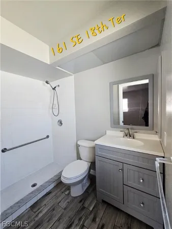 a bathroom with a sink mirror vanity and toilet