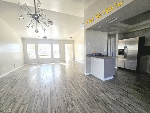 a kitchen with stainless steel appliances wooden floor and a window