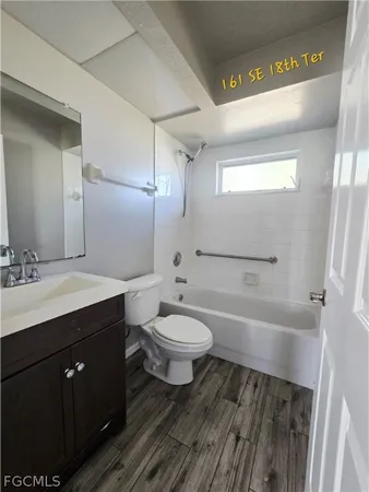 a bathroom with a sink a toilet a mirror and bathtub