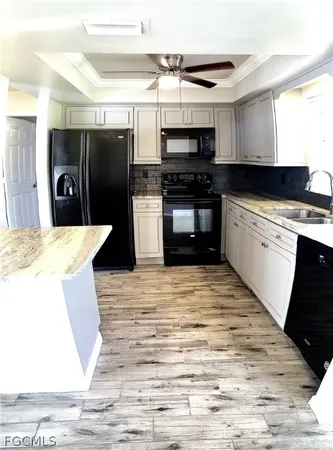 a kitchen with stainless steel appliances kitchen island granite countertop a refrigerator stove top oven and sink