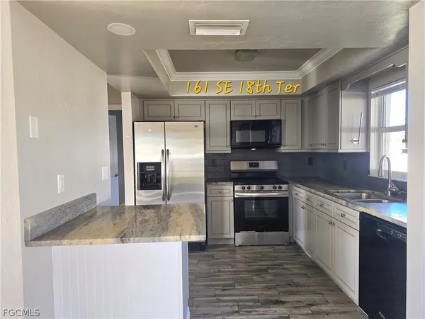 a kitchen with stainless steel appliances granite countertop a stove a refrigerator and a sink